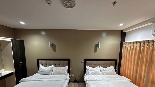 A hotel room with two beds, a wardrobe, a mirror, and a curtain. - Noorway Hotel and Residences (Cagayan de Oro)
