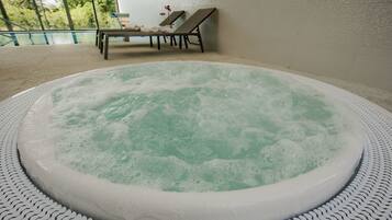 Relax in a serene hot tub surrounded by a patterned floor and lounge chairs.