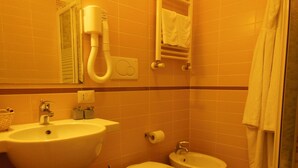 A bathroom with a sink, toilet, bidet, and a towel rack. - Locanda Colosseo (Rome)