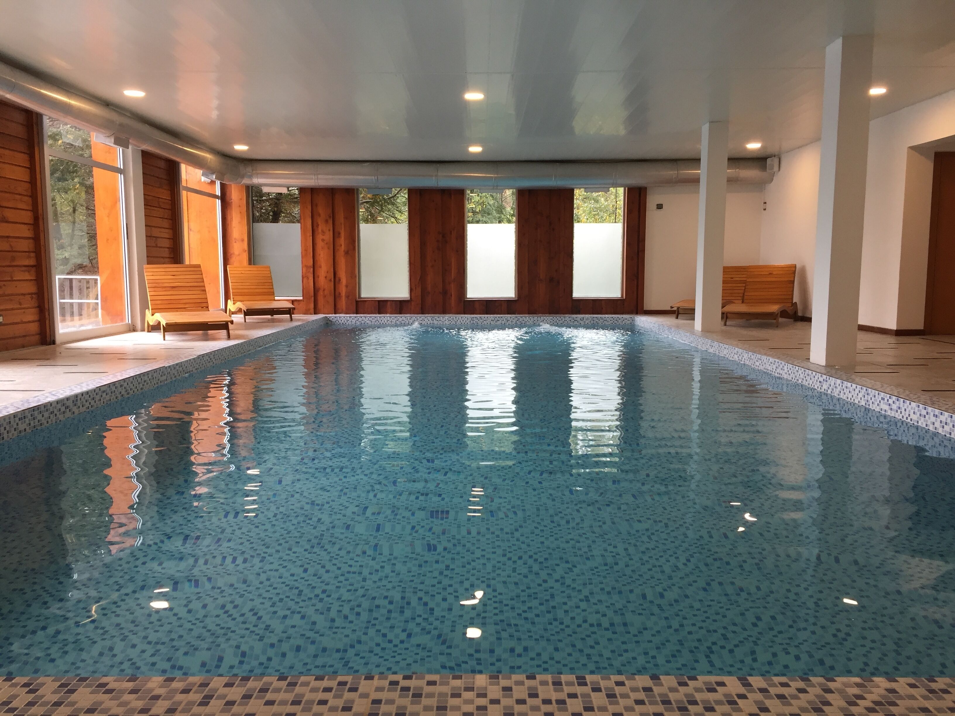 Una piscina cubierta, una piscina al aire libre de temporada, sombrillas