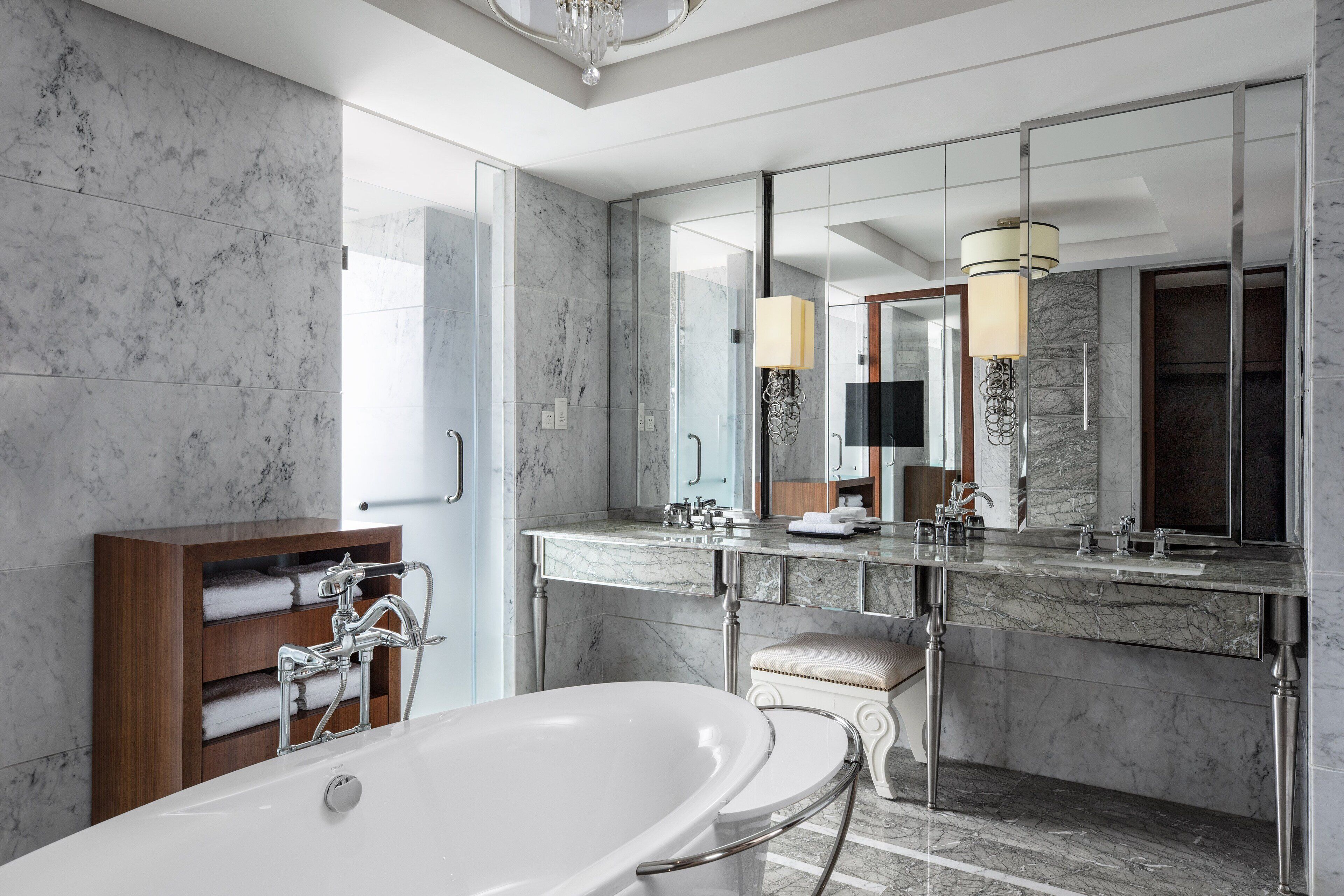 Ein modernes Badezimmer mit einer großen Badewanne, einem мраморному Waschtisch und einem großen Spiegel.