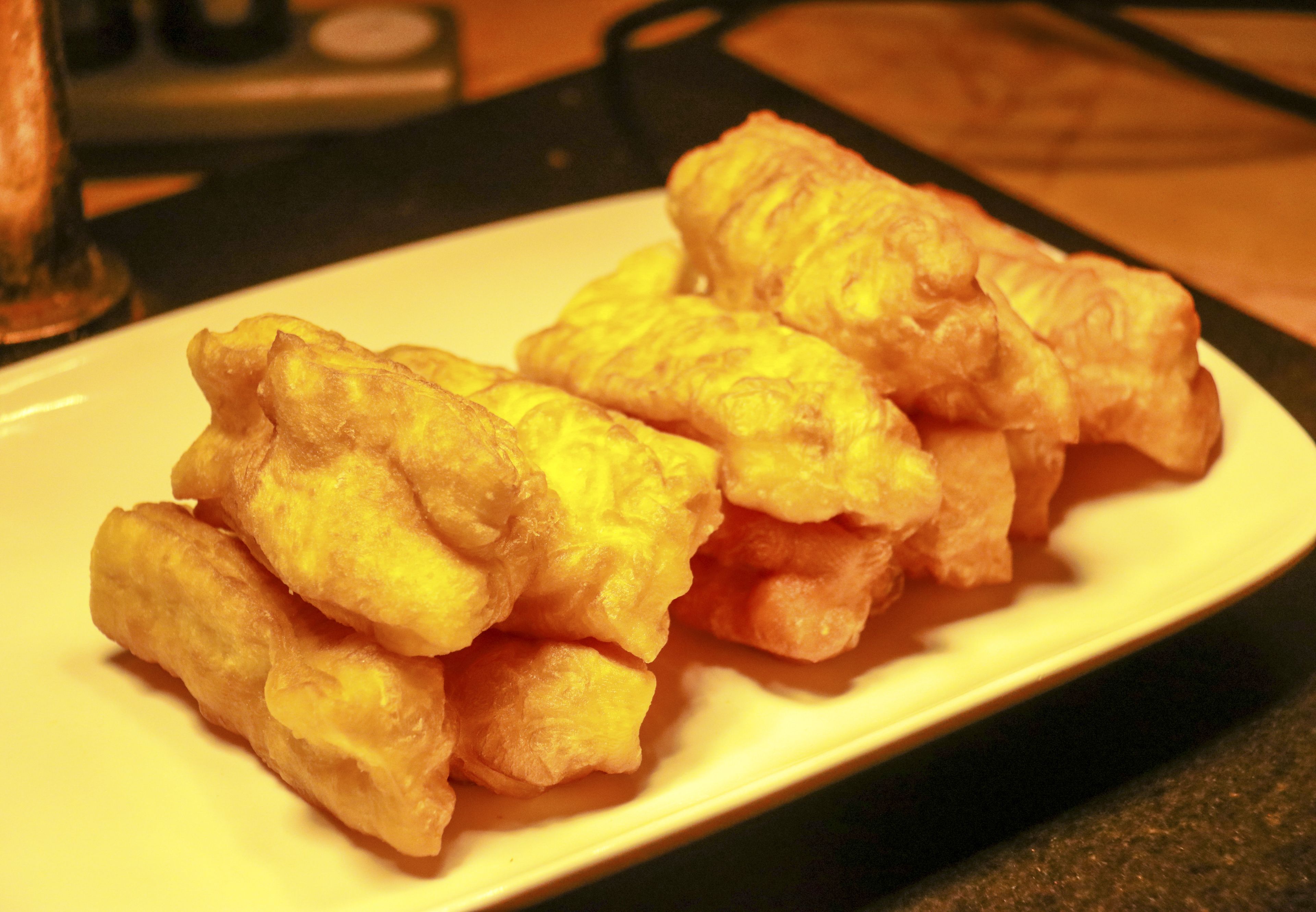 Un plato de buñuelos fritos sobre un plato blanco.