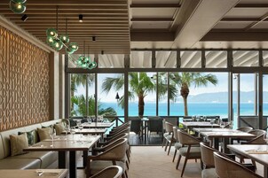 Un restaurante con vista al mar, con mesas y sillas dispuestas para comer.