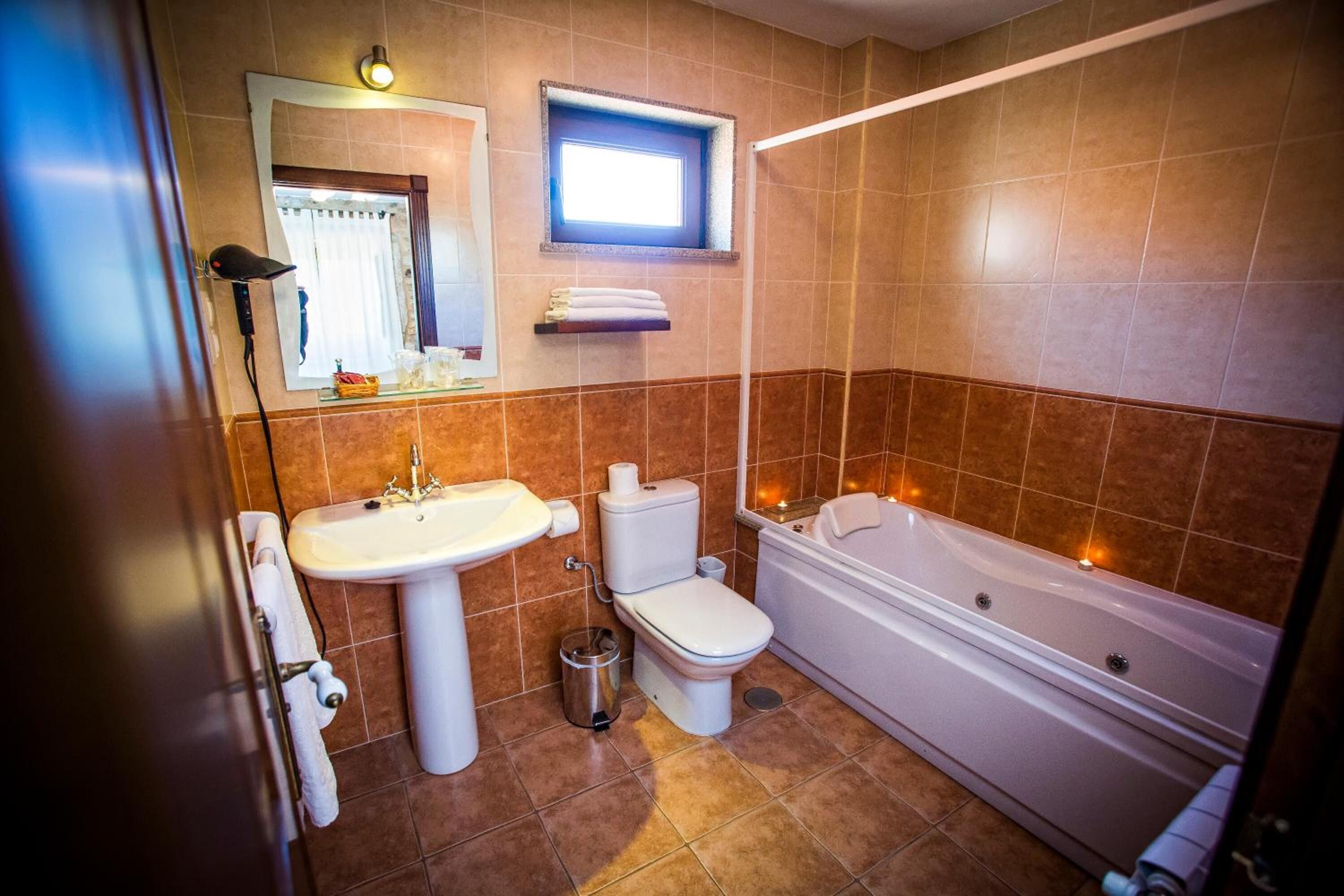 Un baño con lavamanos, inodoro y bañera.