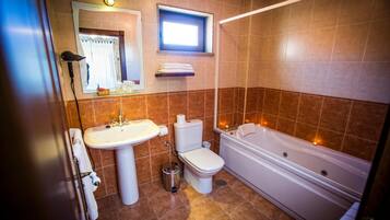 Un baño con lavamanos, inodoro y bañera.