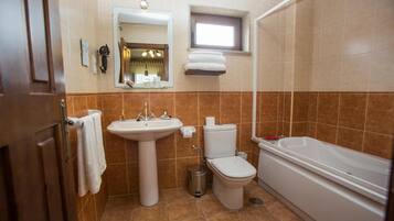 A bathroom with a sink, toilet, and bathtub.