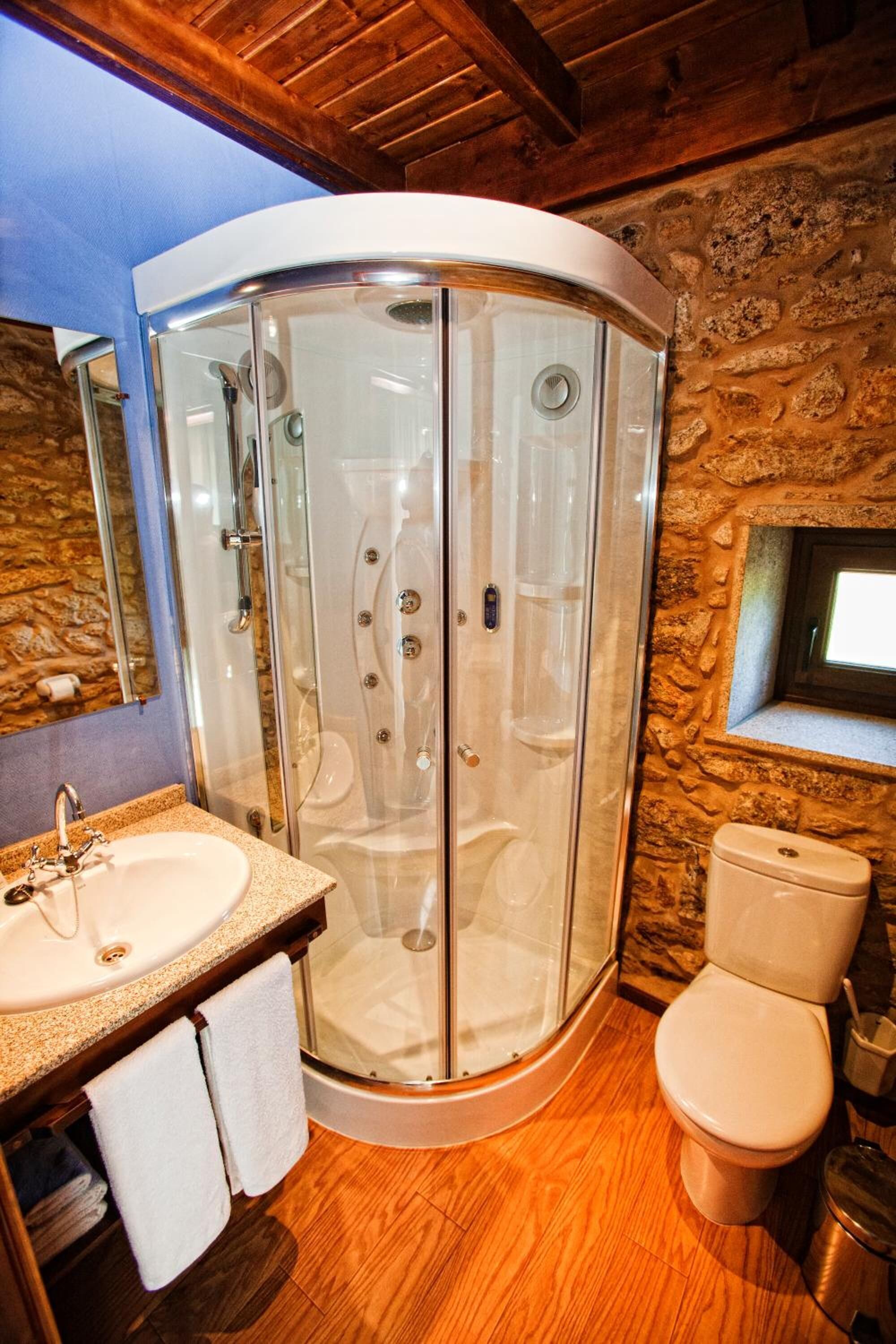 Een badkamer met een douchecabine, een wastafel en een toilet.