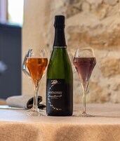Uma garrafa de vinho Montagnieu com dois copos de vinho ao lado.