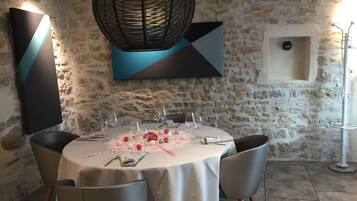 A dining area with a round table set for six, surrounded by six chairs.