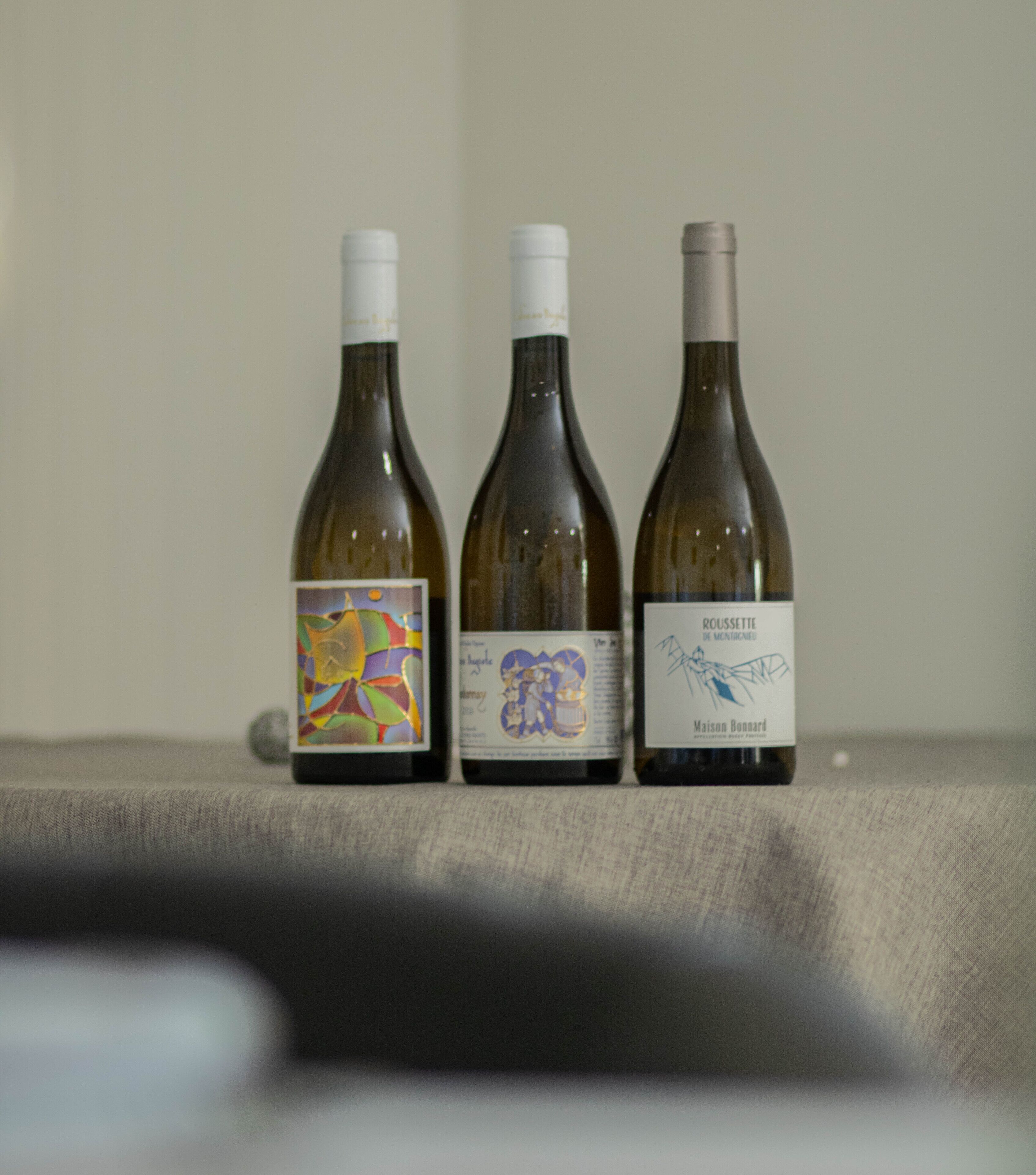 Tres botellas de vino sobre una mesa.