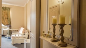 A room with a white sofa, a small table with a vase, and a mirror with candles. - Ryleev Hotel (Kharkiv)