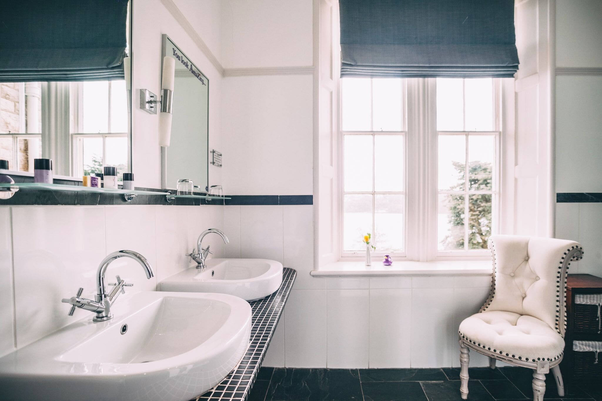 A bathroom with two sinks, a mirror, and a window with a view.