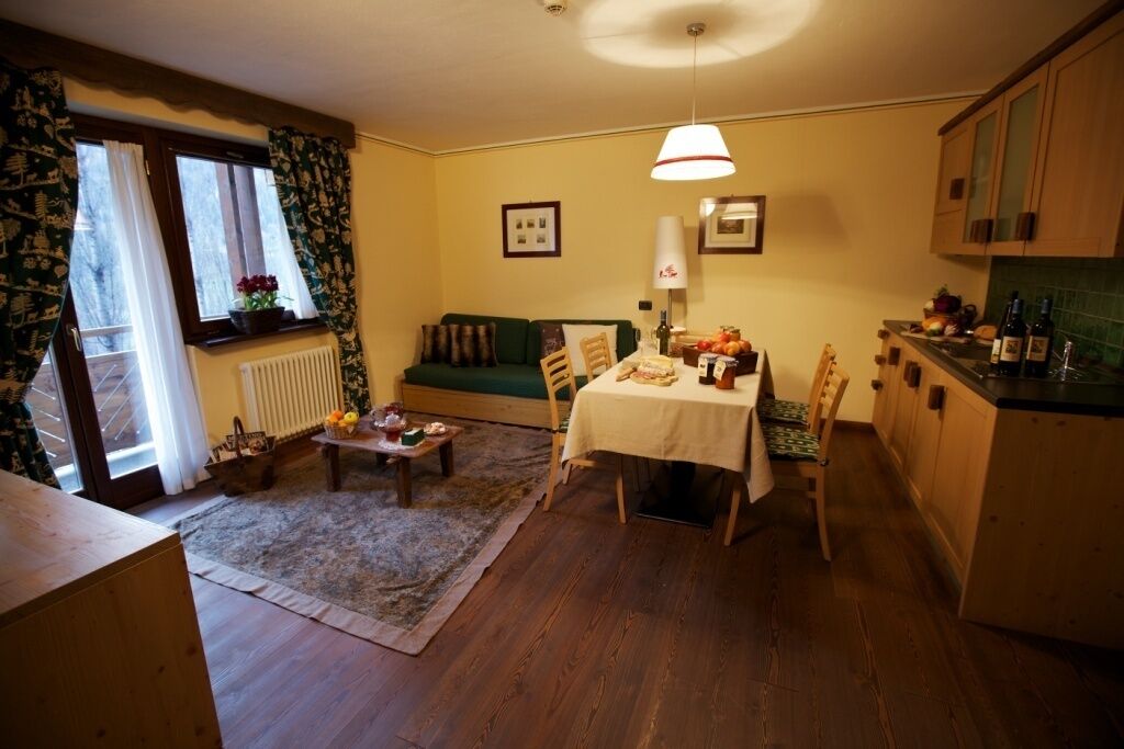 Een gezellige woonkamer met een eettafel, bank en een keukenhoek.