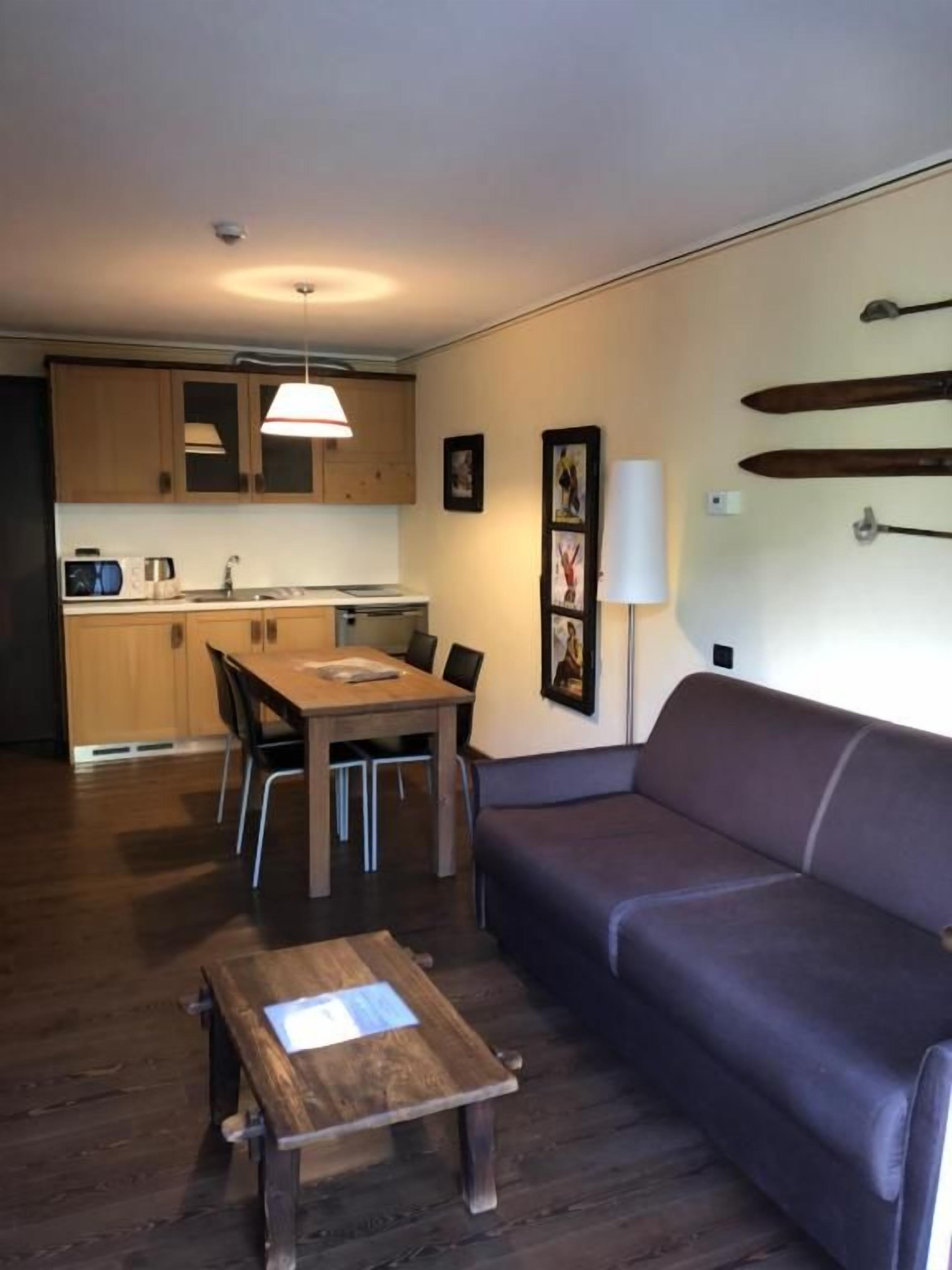 A compact living space with a dining area, a sofa, and a small table.