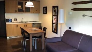A compact living space with a dining area, a sofa, and a small table.