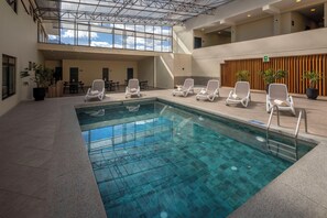 Una piscina techada, sillones reclinables de piscina