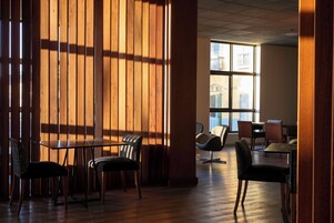 Un comedor moderno con paneles de madera y vistas de la ciudad a través de grandes ventanales.