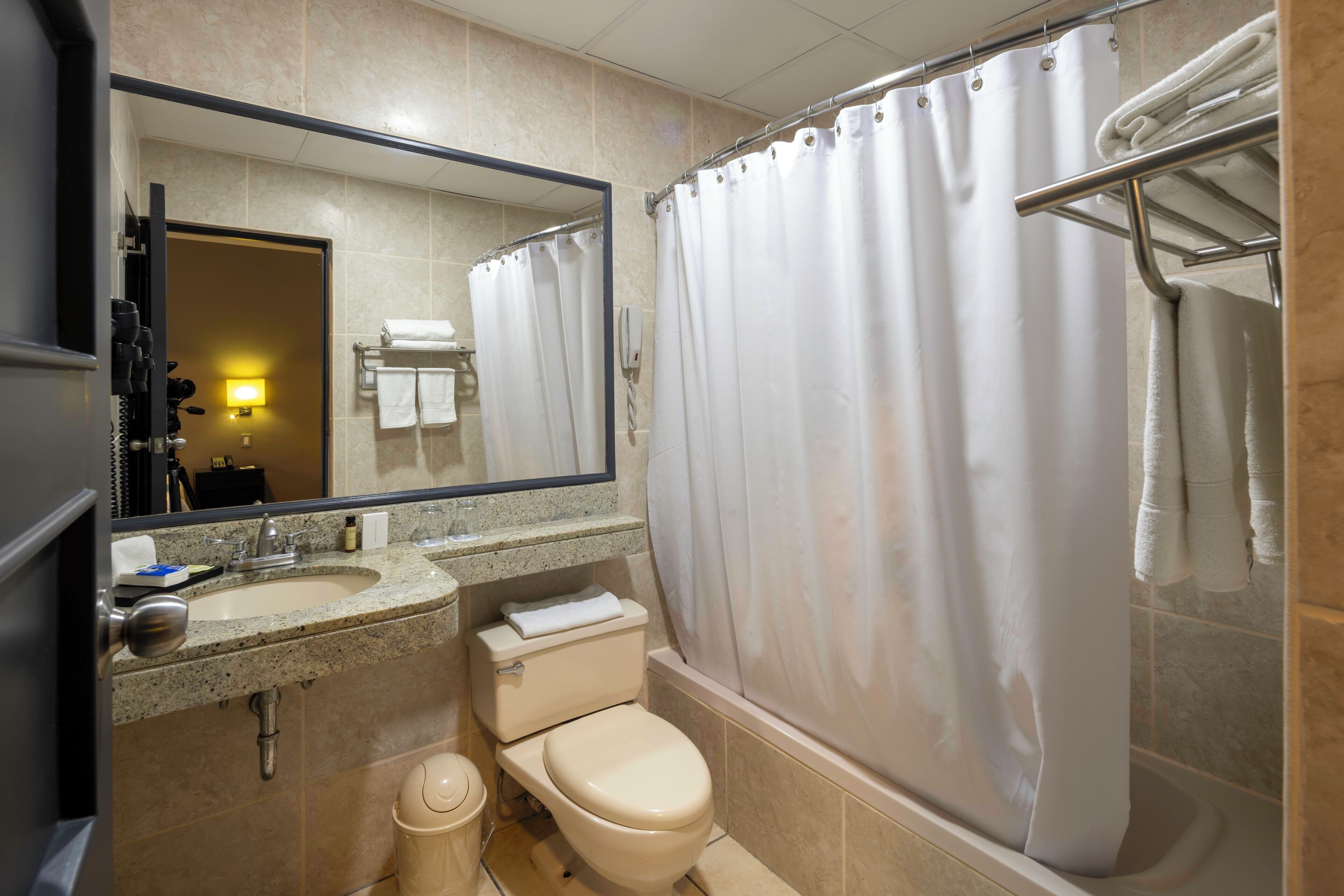 A bathroom with a sink, toilet, and shower area.