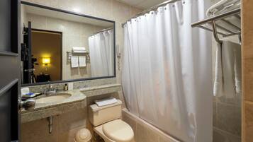 A bathroom with a sink, toilet, and shower area.