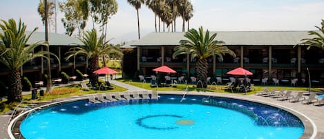 Una piscina al aire libre, sillones reclinables de piscina