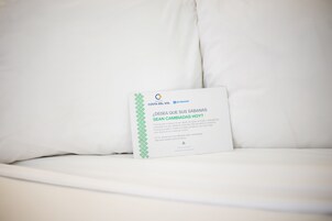 Una cama blanca con una tarjeta encima.