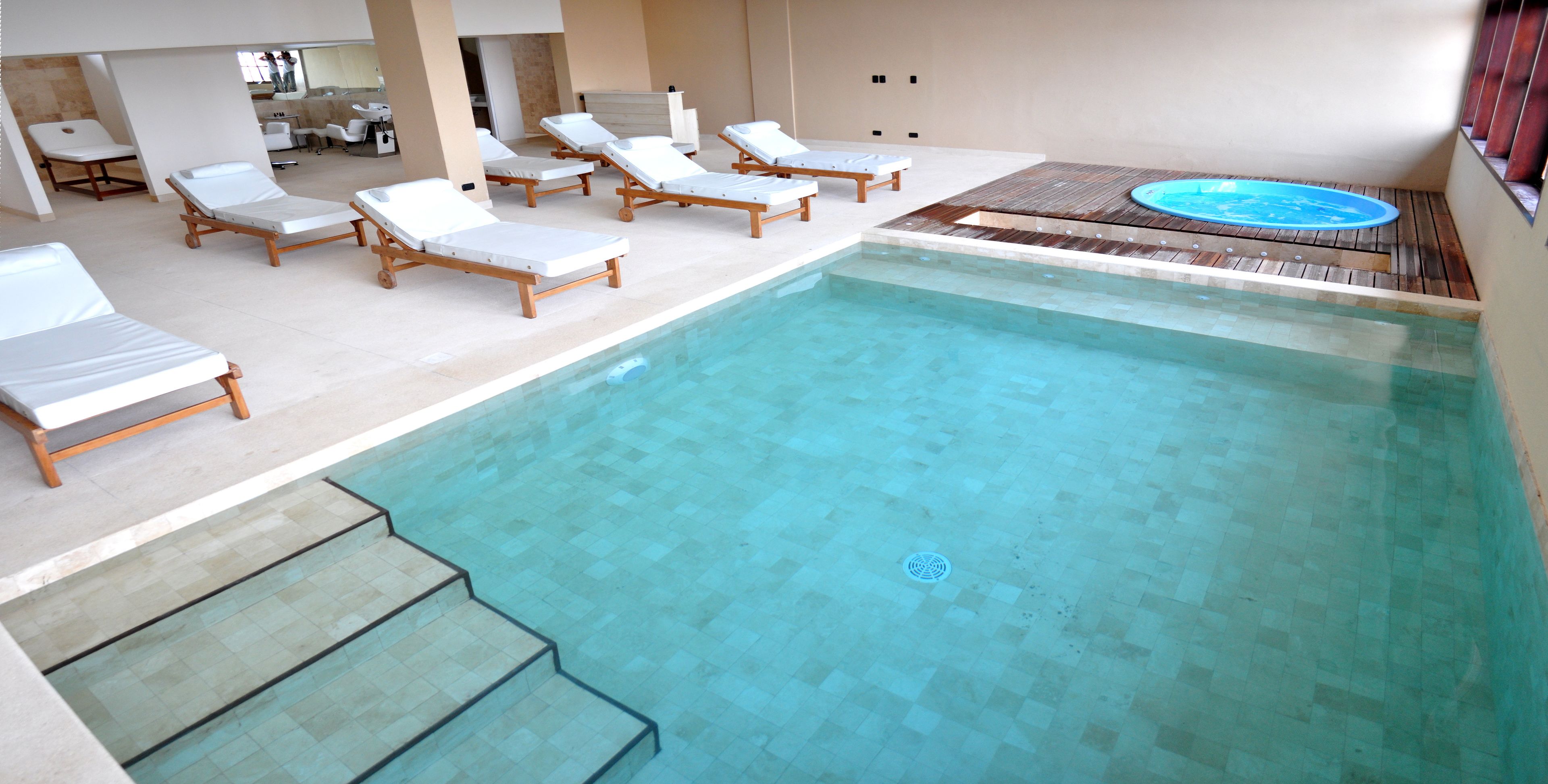Un área de piscina con sillones reclinables y un jacuzzi.