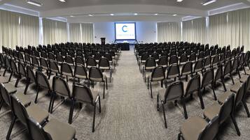 A conference room with rows of chairs facing a projection screen displaying 'COSTA DEL SOL'.