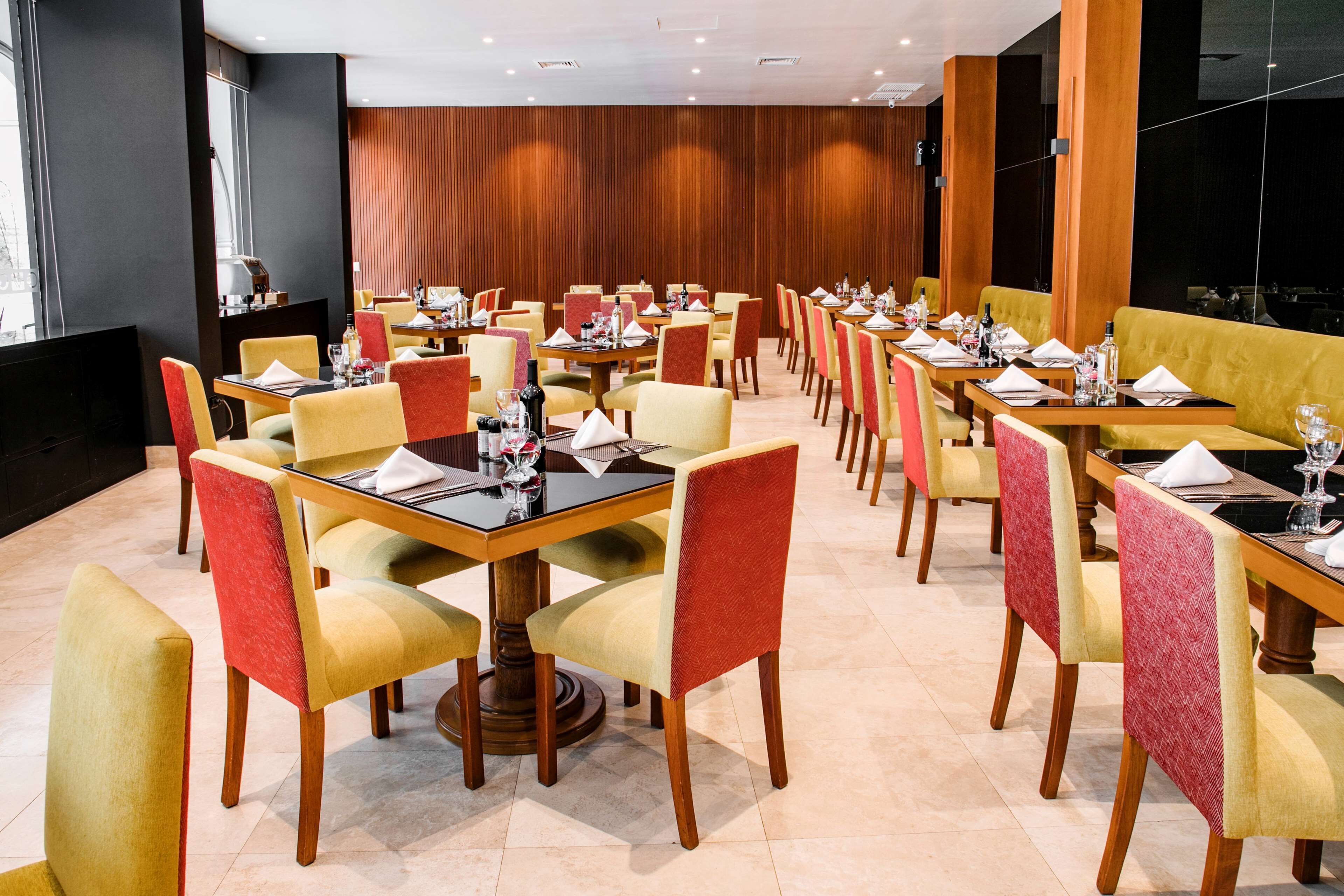 A dining area with multiple tables and chairs, arranged in rows.