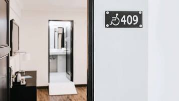 Entrada a una habitación de hotel con un letrero de acceso para sillas de ruedas y una puerta.