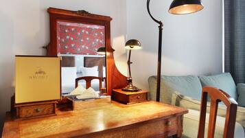 A wooden desk with a lamp, a mirror, and a box labeled "Le Robinet d'Or."