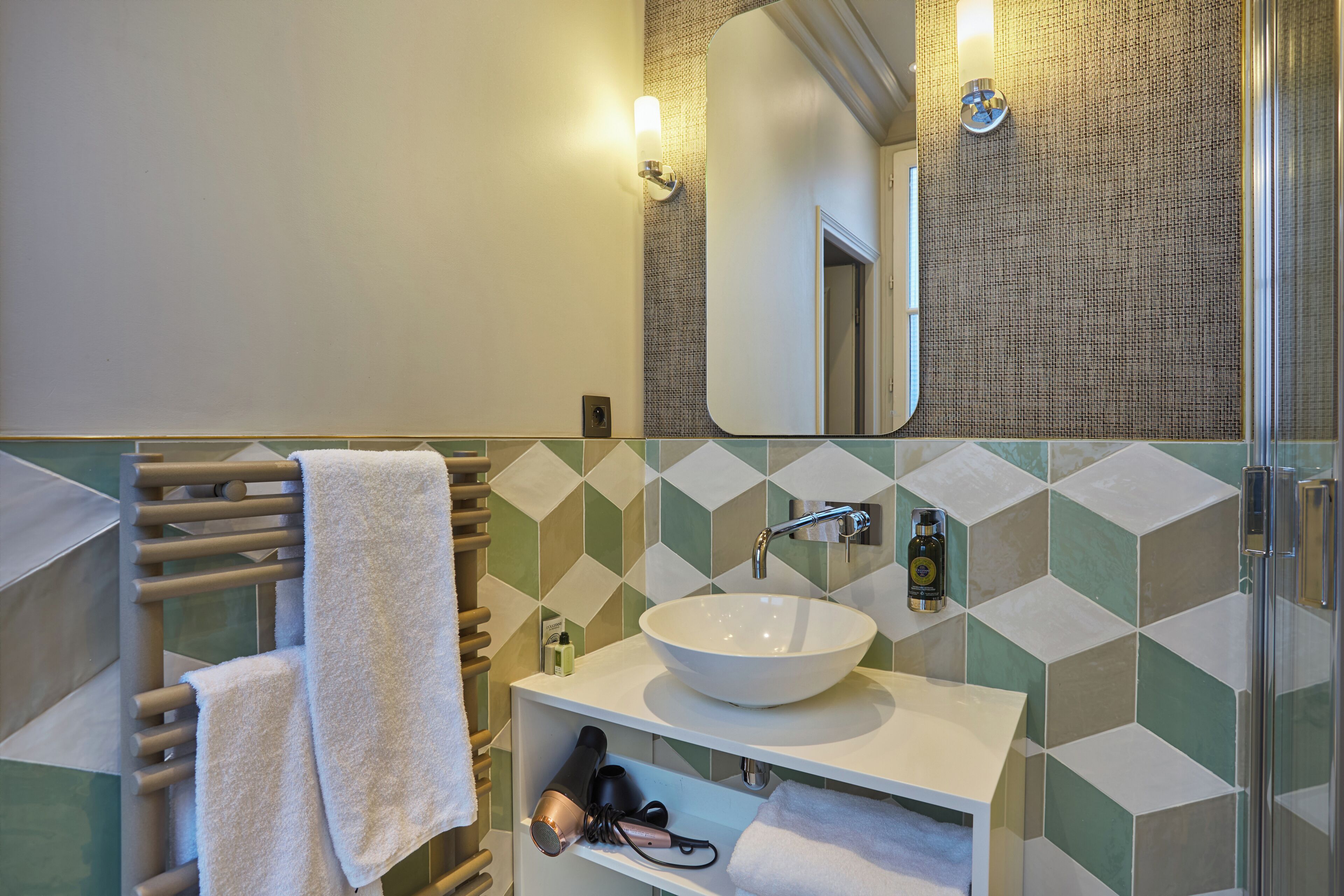 A bathroom with a white sink, a towel rack, and a mirror.