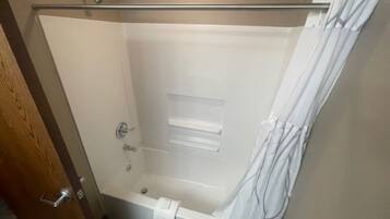 A walk-in shower with a glass door, a towel rack, and a shower curtain.