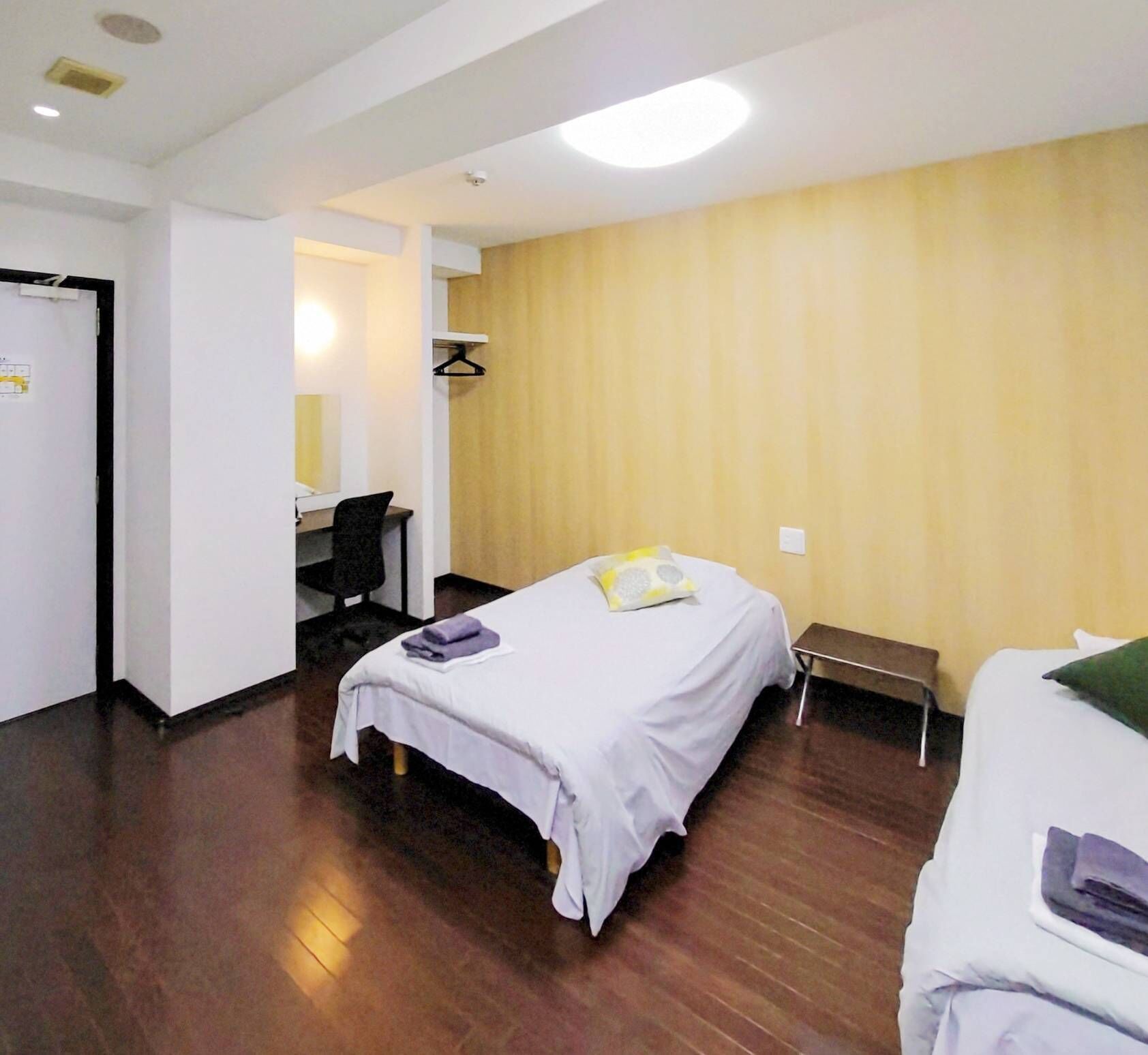 A room with a bed, a desk, and a chair.