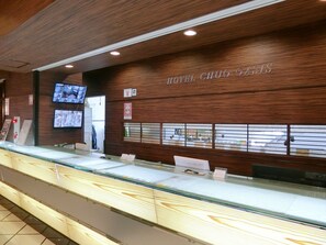 Welcome to Hotel Chuo Oasis, where guests can check in at the reception desk and enjoy the convenience of flat-screen TVs and informational posters.