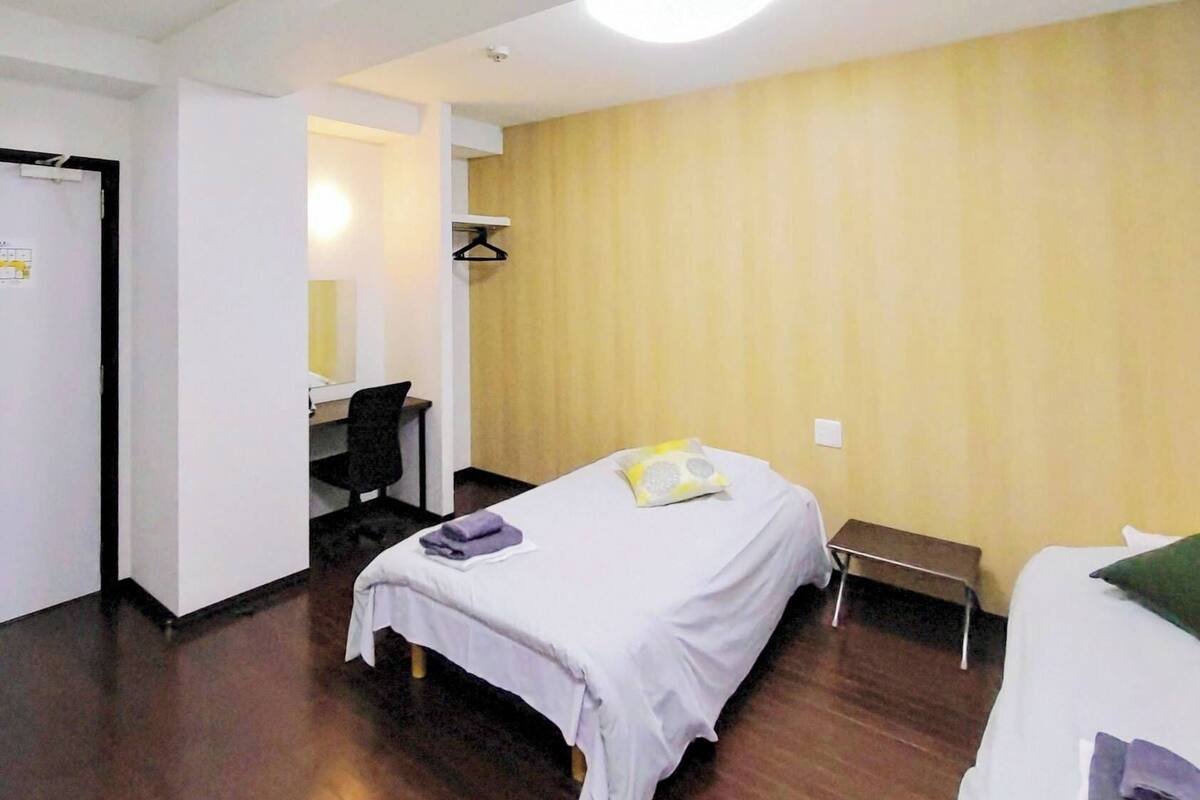 A hotel room with a bed, a desk, and a chair.