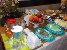 Bőséges reggeli büfé, melyben különféle ételek – például gyümölcsök, sütemények és tejtermékek – állnak rendelkezésre.