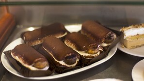 A plate of dessert items, likely pastries, with a creamy filling and a chocolate topping.