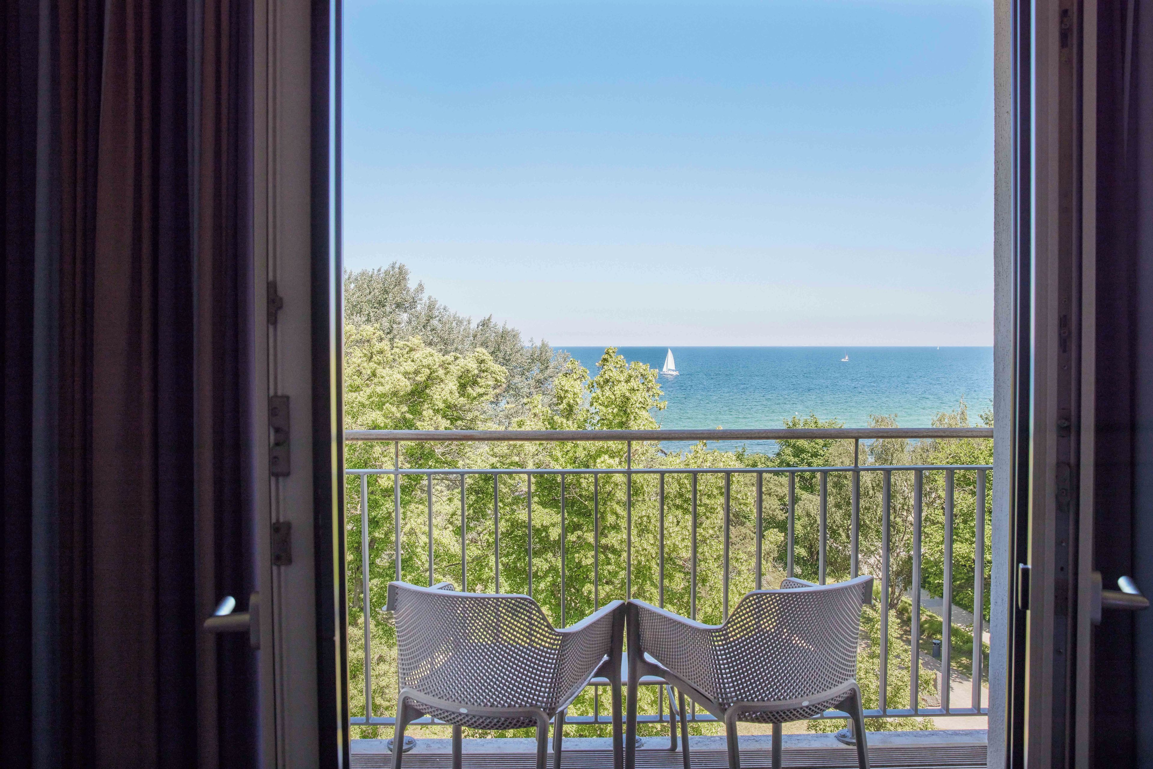 Ein offener Balkon mit zwei Stühlen, der auf den Meerblick ausgerichtet ist.