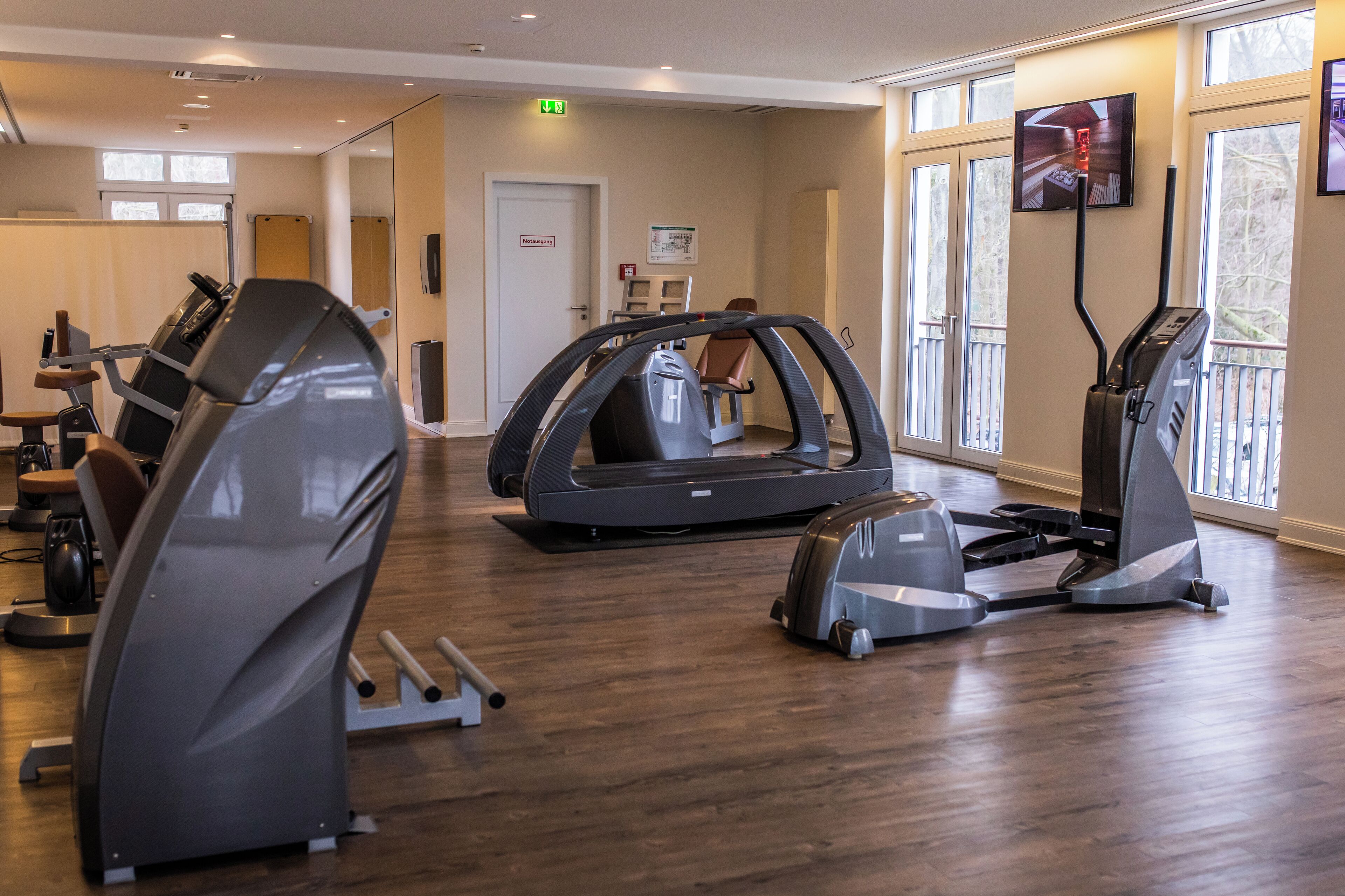 A gym with treadmills, stationary bikes, and a rowing machine.