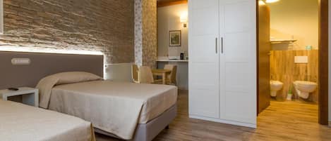 A bedroom with a bed, bedside tables, a wardrobe, and a bathroom visible through an open door.