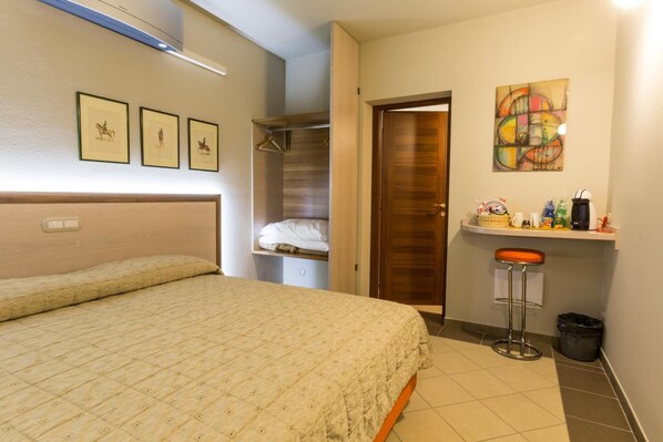 Un dormitorio con cama, armario, baño con ducha y una pequeña zona de bar.