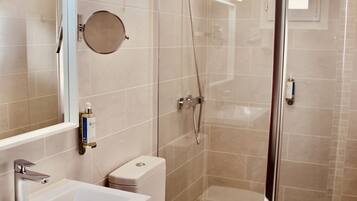 A bathroom with a sink, toilet, and shower.