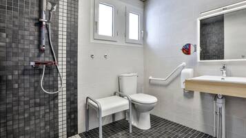 A modern bathroom with a shower, toilet, and sink.