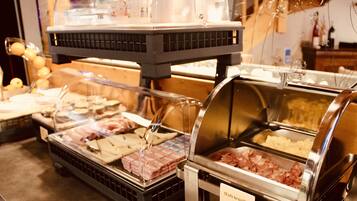 A buffet with various food options including bacon, cheese, and other prepared dishes.