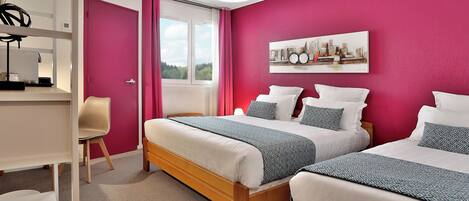 A bedroom with two beds, a desk, and a chair.