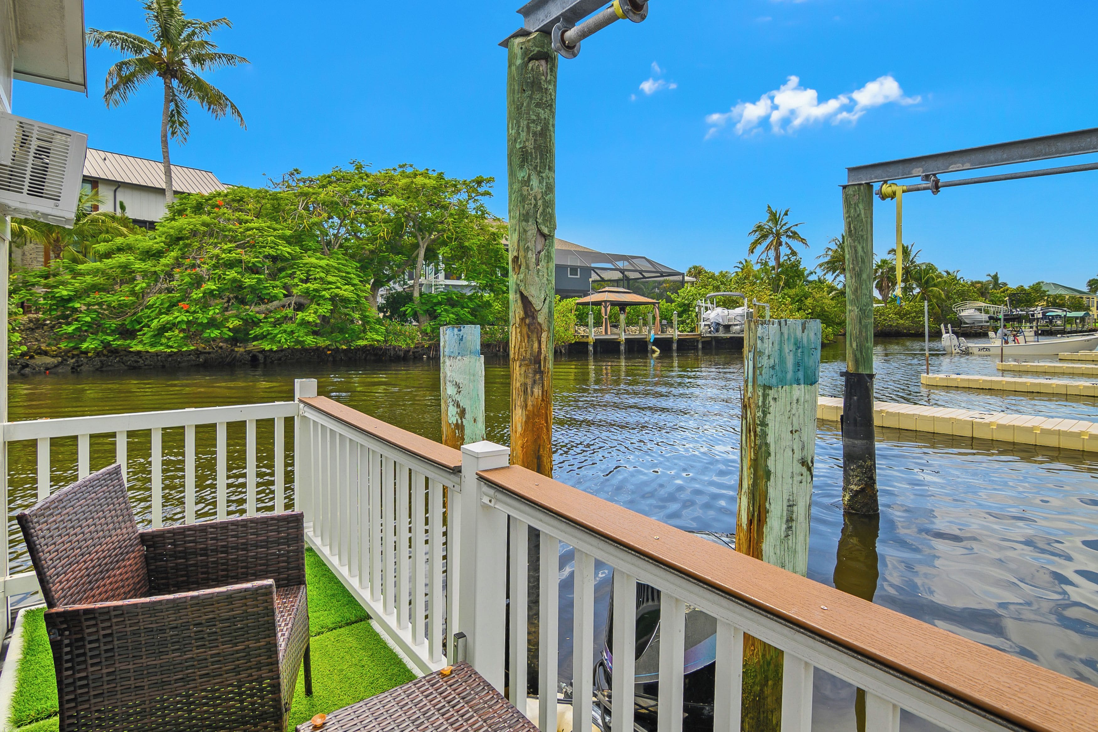 A waterfront property with a deck, outdoor furniture, and a view of the water.