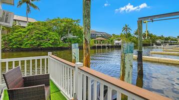 A waterfront property with a deck, outdoor furniture, and a view of the water.