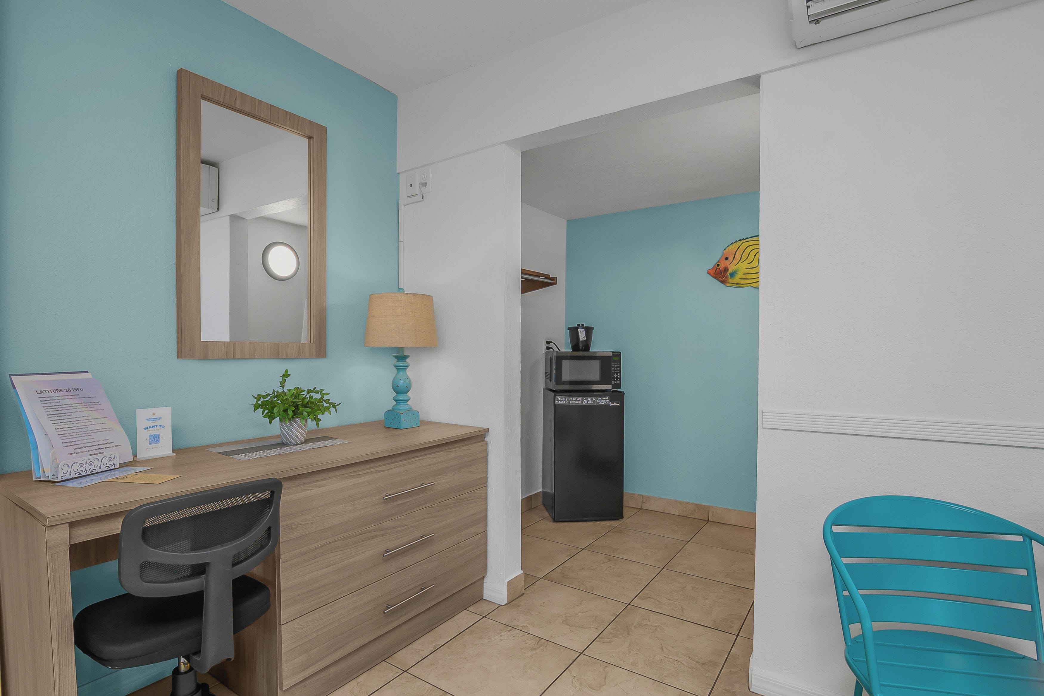 Een hotelkamer met een bureau, stoel en een magnetron.
