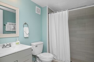 A bathroom with a white sink, a toilet, and a shower curtain.