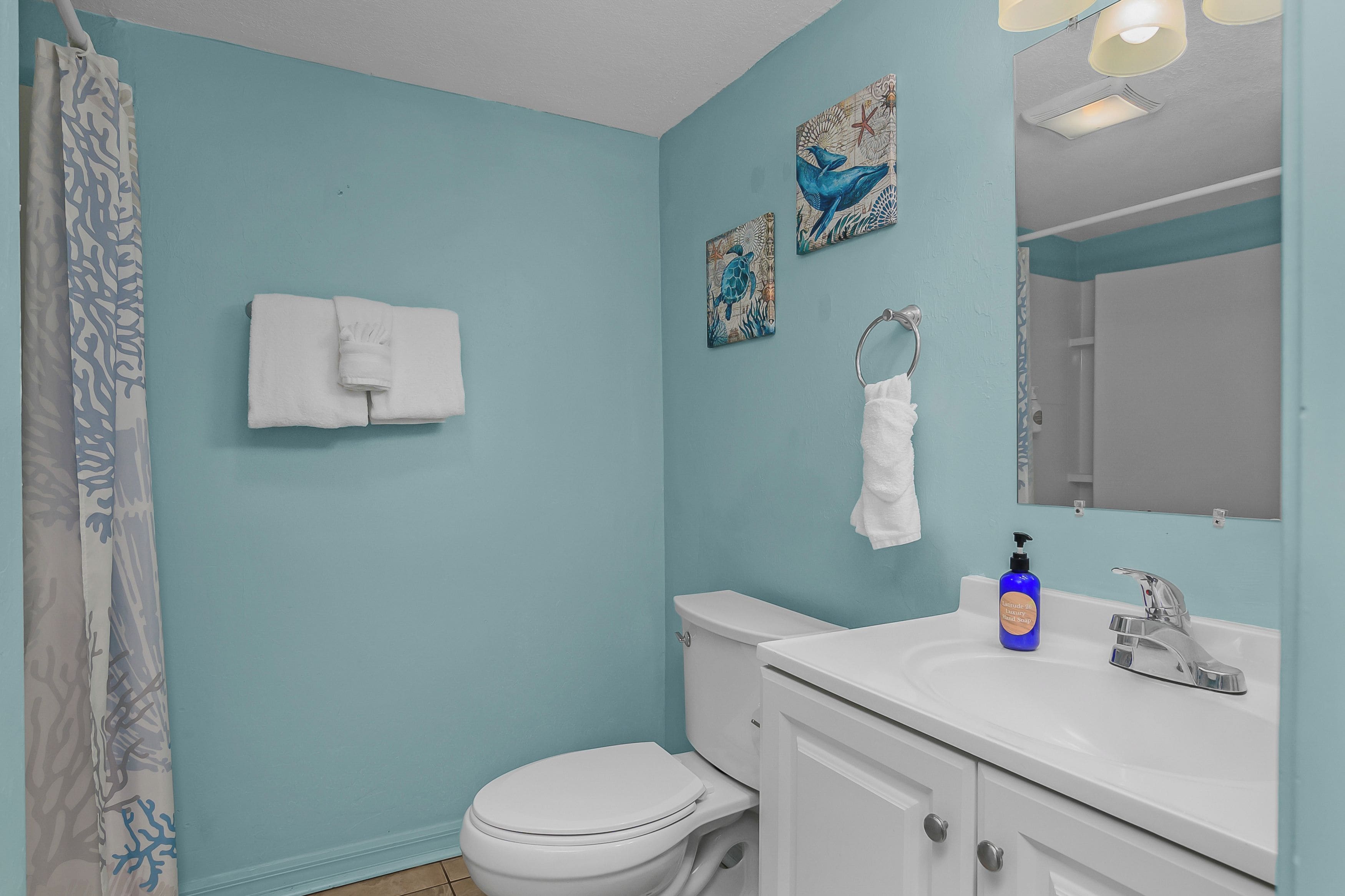 A bathroom with a toilet, sink, and a towel rack.